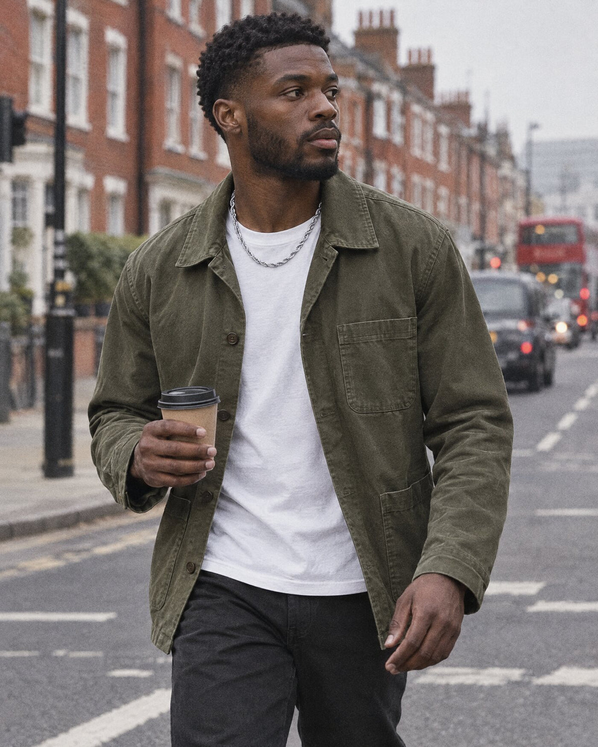 A man crossing a London street wearing a silver chain
